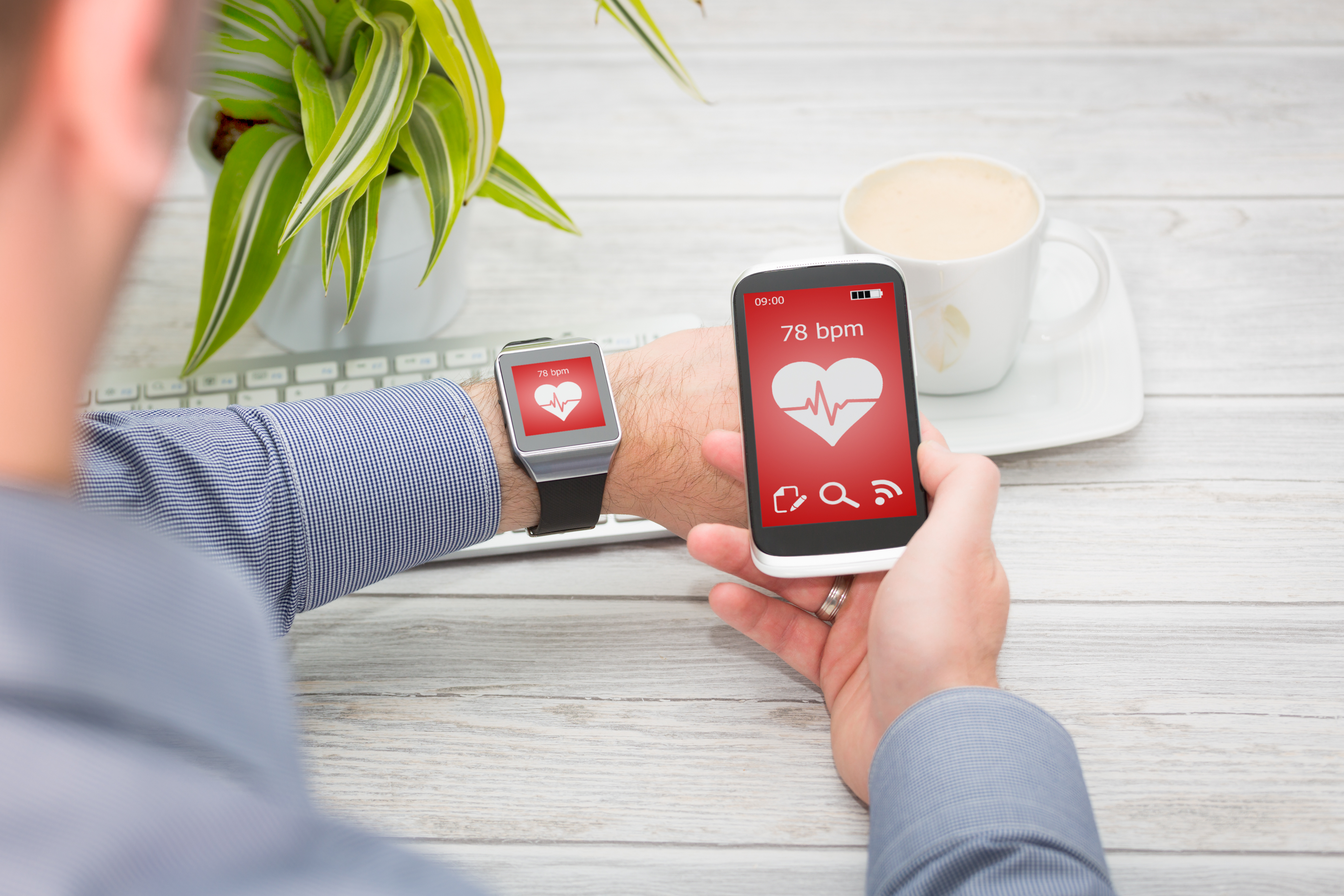 Businessman uses smart watch and phone.